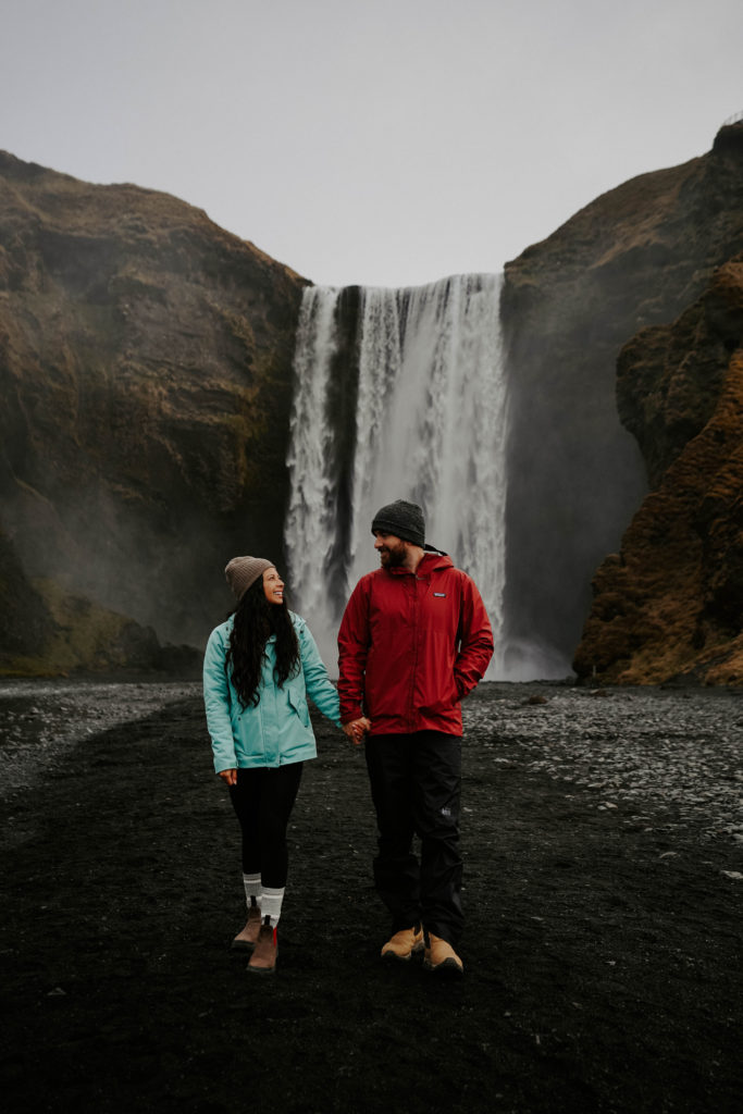 Couple in front of Skogafoss waterfall Iceland 