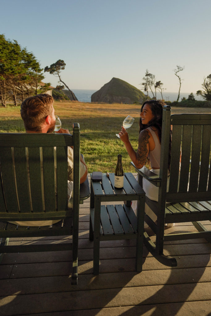 Couple drinking wine on deck overlooking the Mendocino Coastline