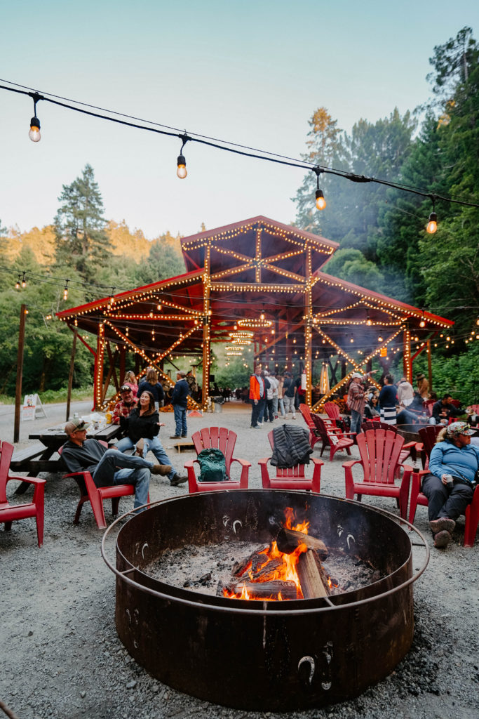 Red barn with a fireplace and twinkly lights in redwood forest