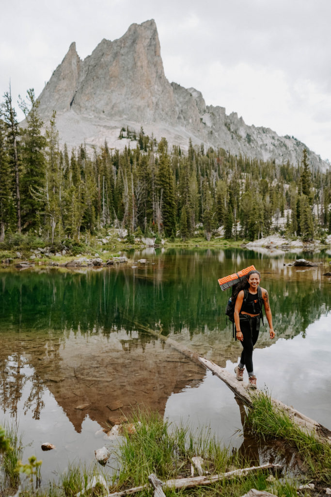 girl in front of alpine lake with a pack