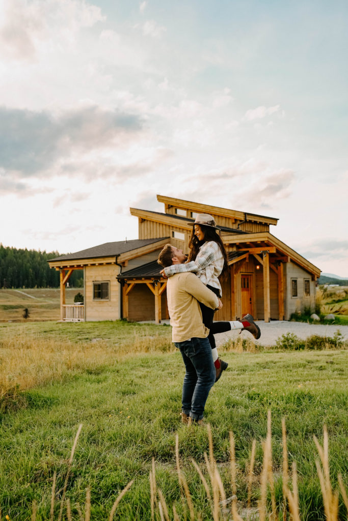 Couple shot in front of Clydesdale Outpost cabin
