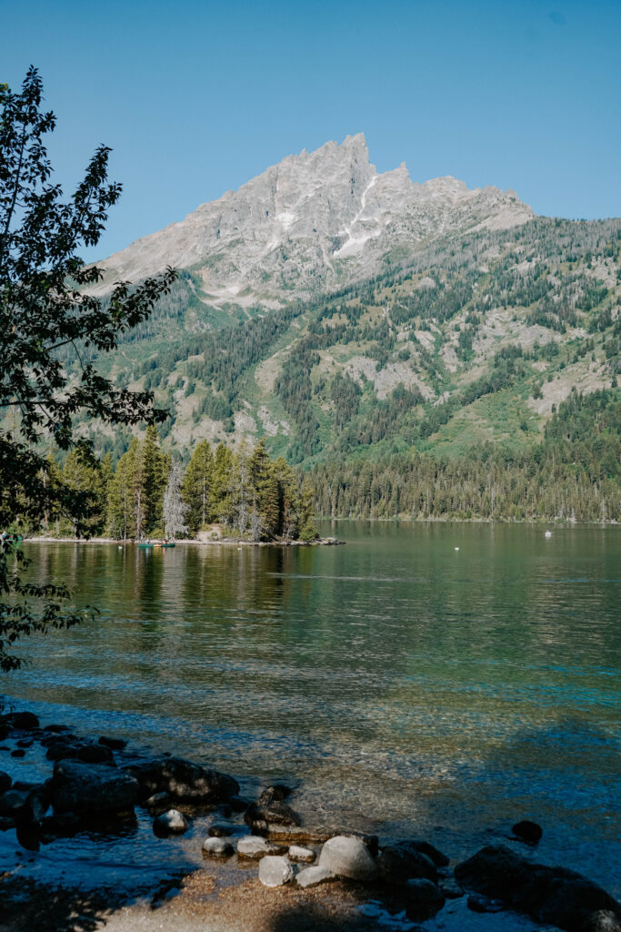 Green lake with a sharp mountain peak from a distance