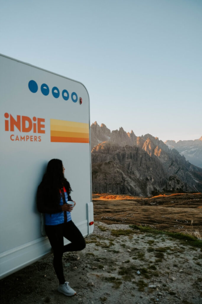 girl standing in front of a campervan in dolomites italy
