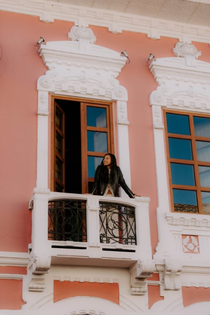 girl standing in front of a balcony in quito ecuador